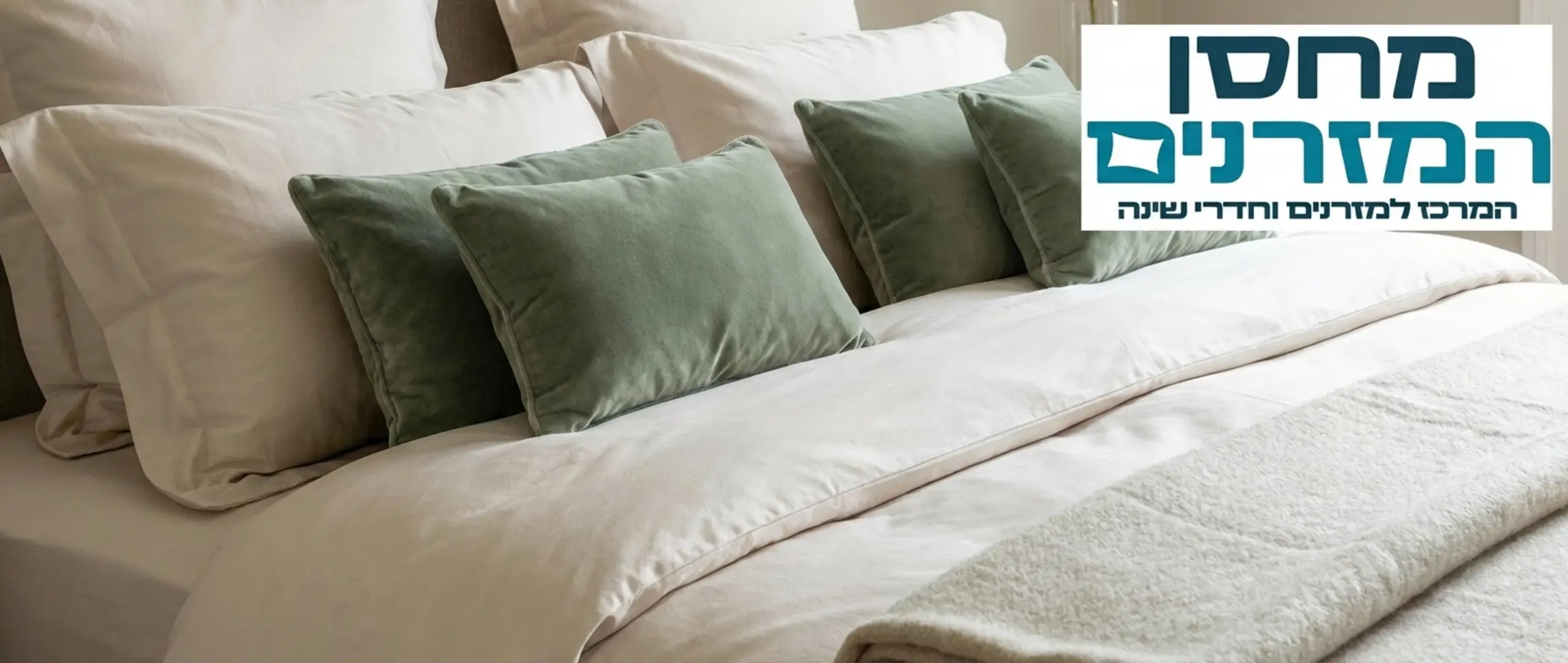 תקריב של מצעי כותנה איכותיים בצבע פנינה על מזרן זוגי, עם מספר כריות נוי מבד קטיפה בצבע ירוק מרווה ושמיכת חורף עבה ומזמינה מונחת בקצה המיטה. התמונה משדרת חמימות, רכות וטקסטורה עשירה. אין דמויות בתמונה.